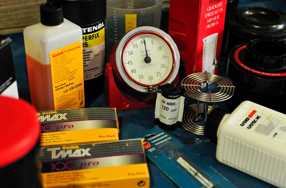 Close-up of film developing equipment including spools, bottles, and a timer.